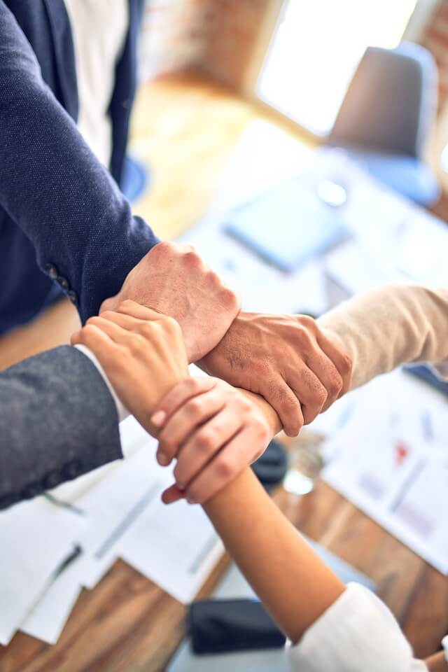 a group of peoples touching hands